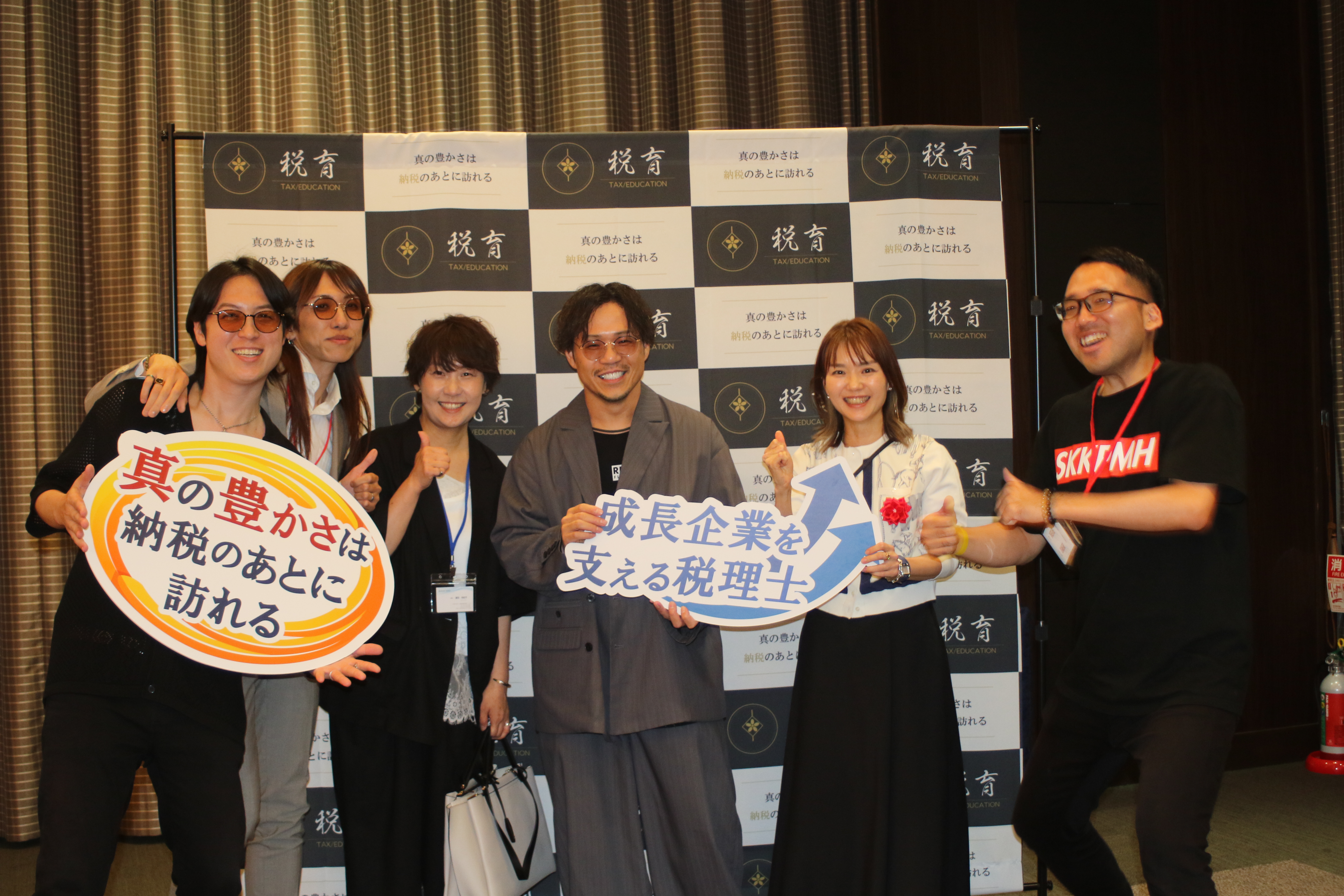 メッセージボードを持って並ぶ税育フェス2026の参加者